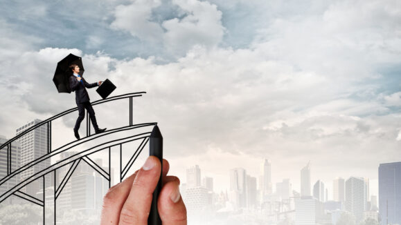 Confident,Businessman,Walking,On,Drawn,Bridge,Over,Gap