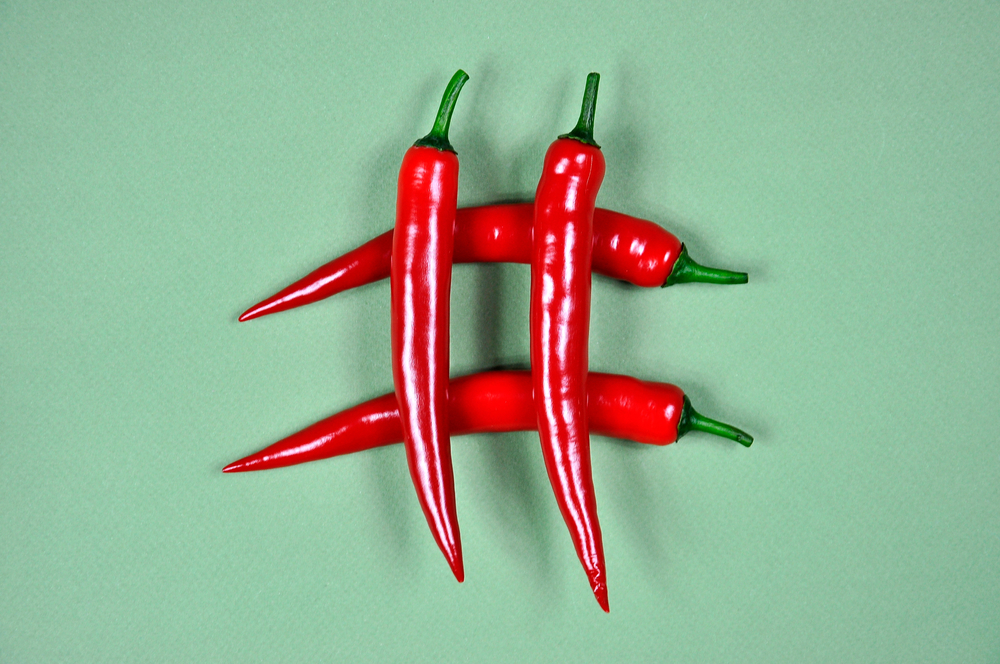 Hashtag.,Red,Hot,Chili,Pepper,On,A,Green,Background.