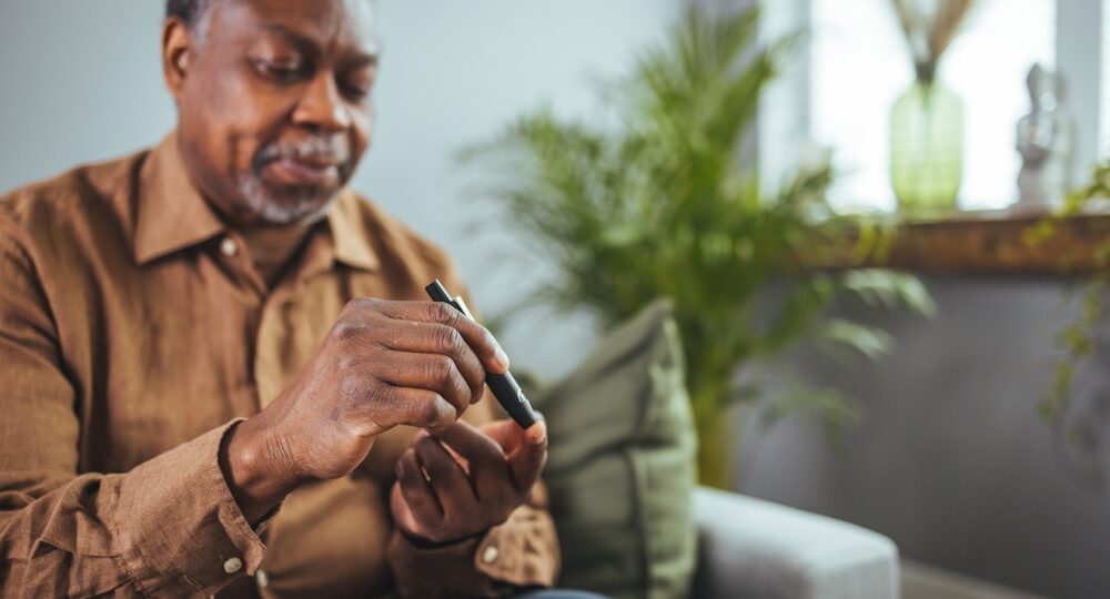 Senior,African,Man,Hands,Using,Lancet,On,Finger,To,Check