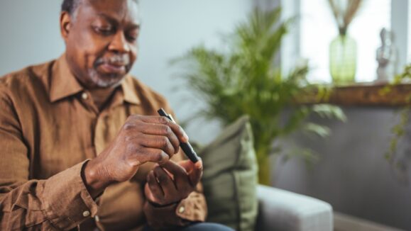 Senior,African,Man,Hands,Using,Lancet,On,Finger,To,Check