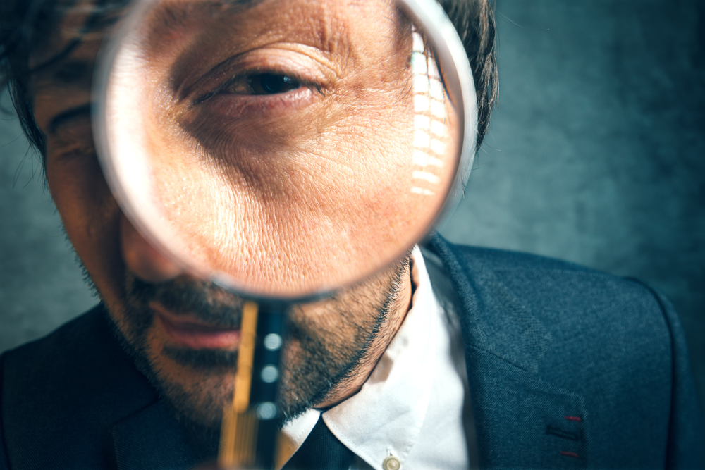 Enlarged,Eye,Of,Tax,Inspector,And,Financial,Auditor,Looking,Through